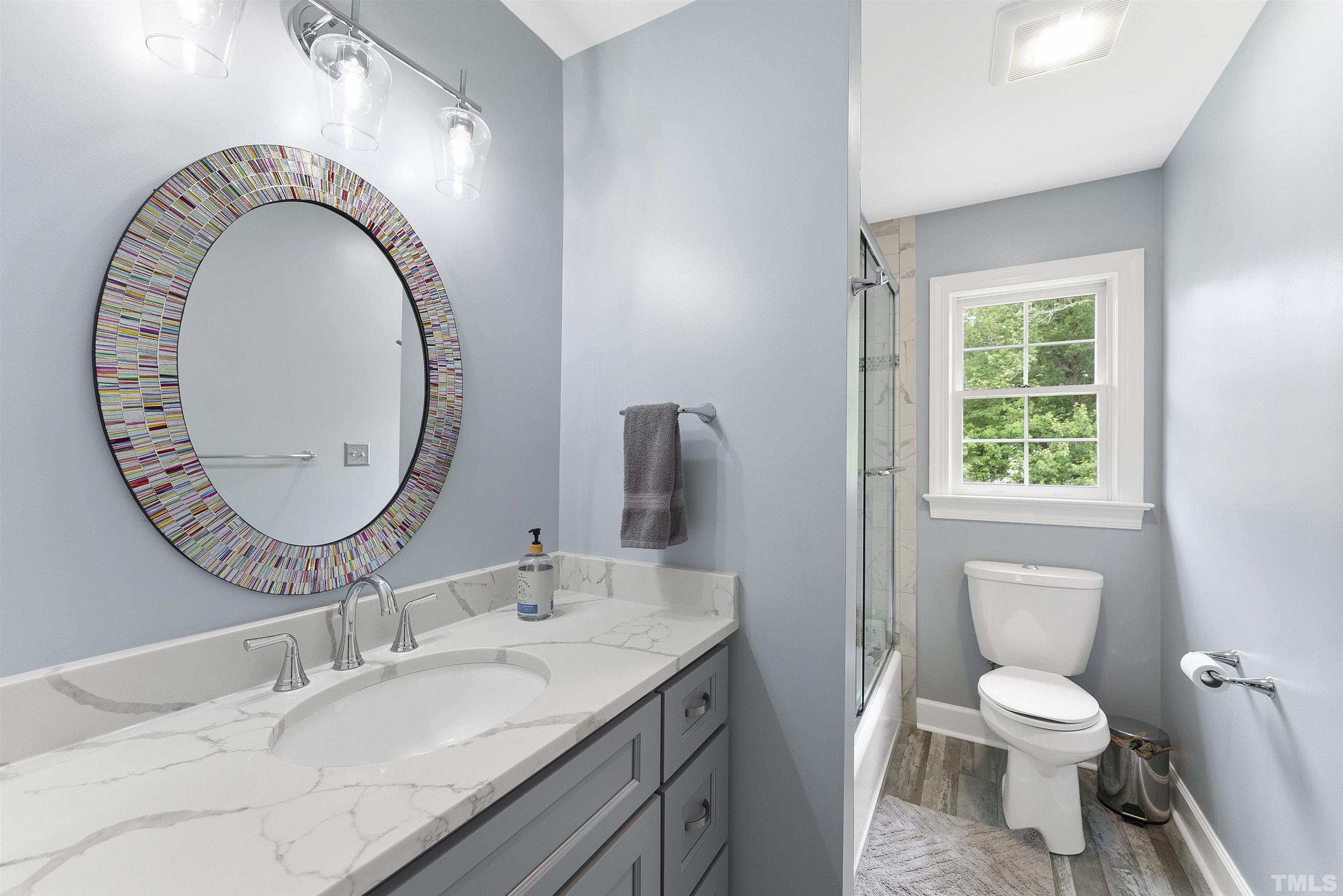 12304 Tappersfield Court Raleigh, NC 27613 - Photo 30 of 41 a bathroom with a granite countertop toilet a sink and a mirror