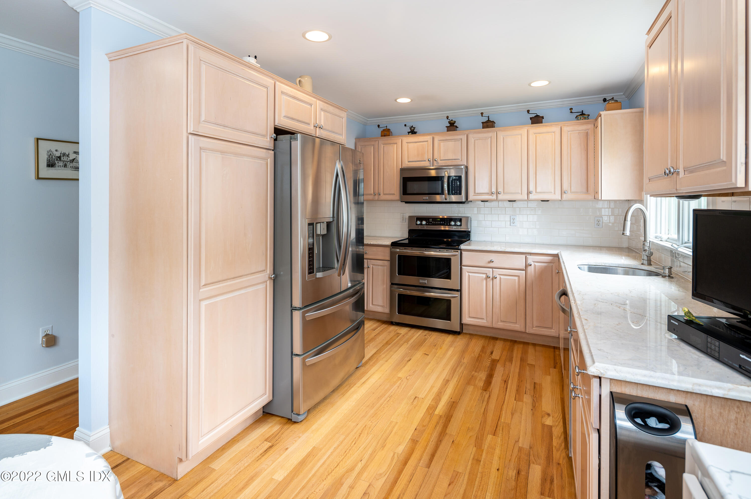 53 Rodwell Avenue, Unit B Greenwich, CT 06830 - Photo 5 of 33 a kitchen with kitchen island wooden floors appliances and cabinets