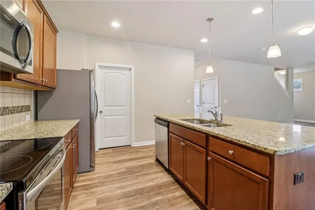 a kitchen with stainless steel appliances granite countertop a sink and a refrigerator