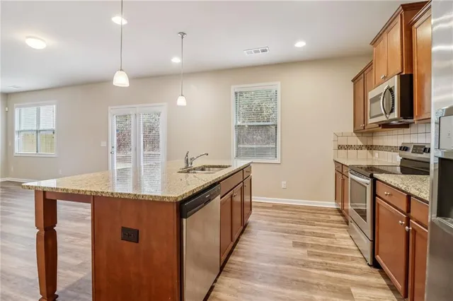 a kitchen with stainless steel appliances granite countertop a sink and stove