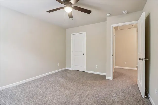 an empty room with closet and a chandelier fan