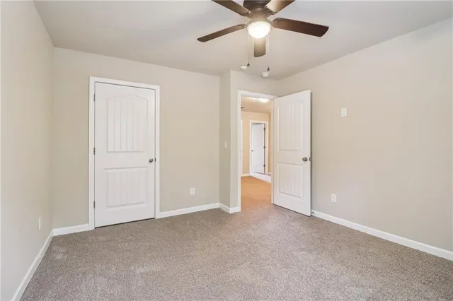 an empty room with chandelier fan