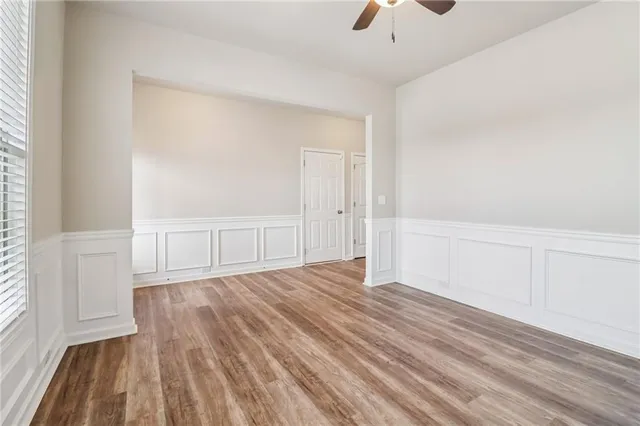 a view of an empty room with window and wooden floor