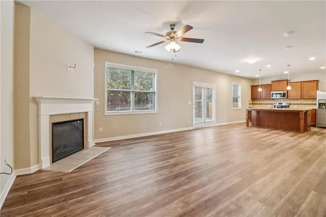 a view of an empty room with a kitchen and fireplace