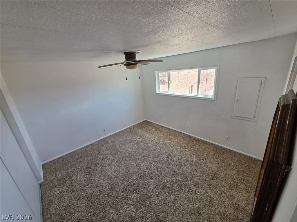 2930 Frehner Ranch Road Pioche, NV 89043 - Photo 27 of 39 A comfortable bedroom features plush carpet and a convenient ceiling fan for optimal comfort.