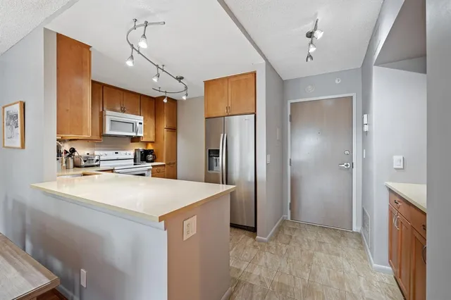 a kitchen with stainless steel appliances a refrigerator sink and cabinets