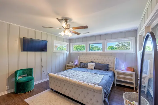 a bedroom with a bed window and a flat screen tv