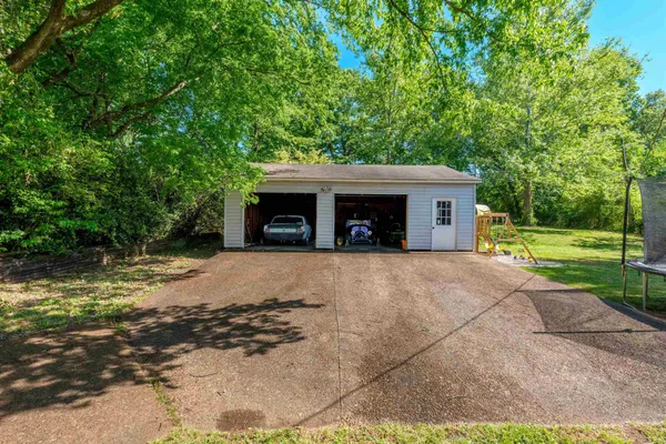a view of a house with a yard and large tree