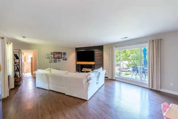 a living room with furniture wooden floor and a flat screen tv