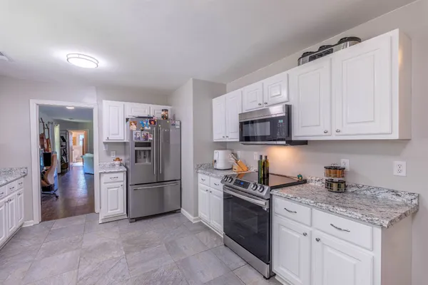 a kitchen with stainless steel appliances granite countertop a refrigerator stove and microwave