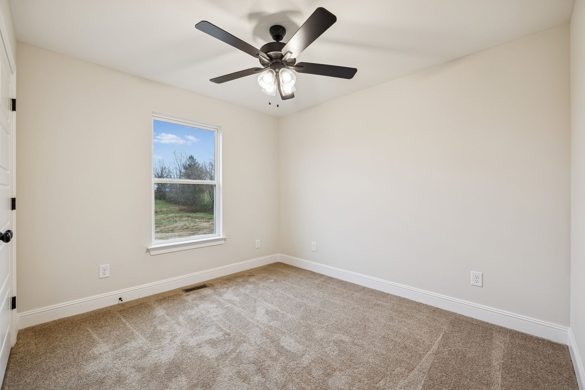 1015 Landing Lane Adams, TN 37010 - Photo 18 of 27 an empty room with a ceiling fan and window