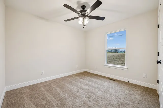an empty room with closet and a chandelier fan