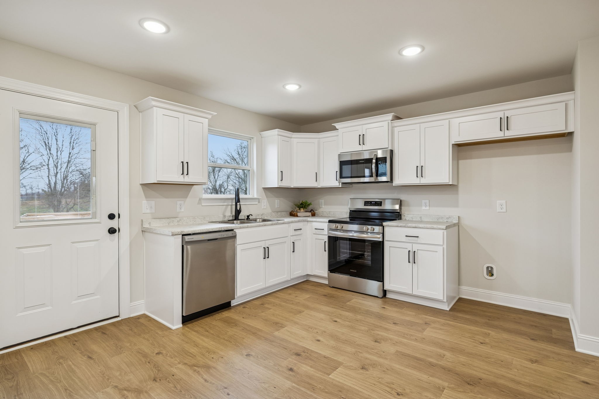 1015 Landing Lane Adams, TN 37010 - Photo 7 of 27 a kitchen with granite countertop white cabinets and stainless steel appliances