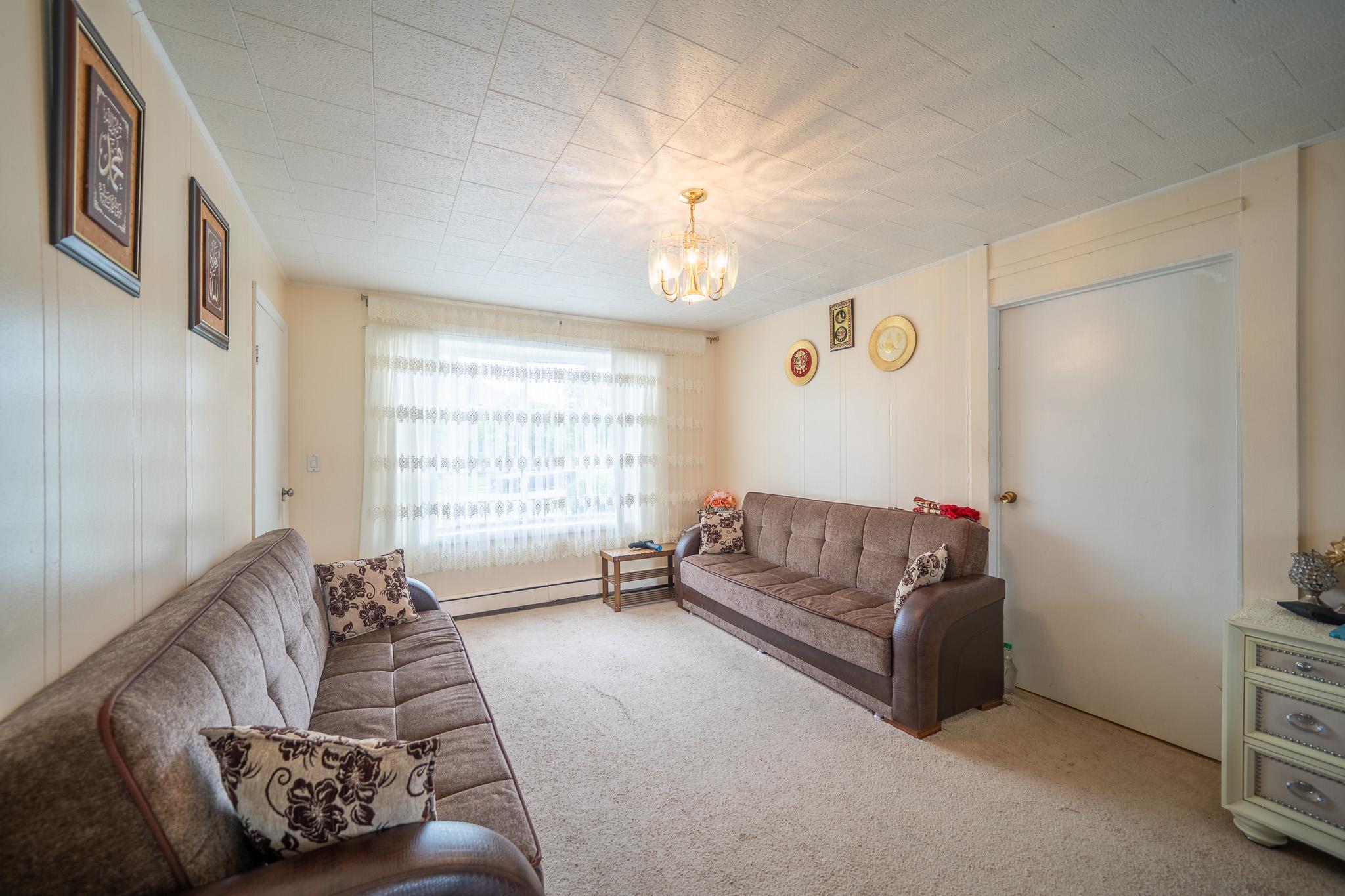 47 Cardinal Road Levittown, NY 11756 - Photo 4 of 27 Carpeted living area with a chandelier and a baseboard heating unit