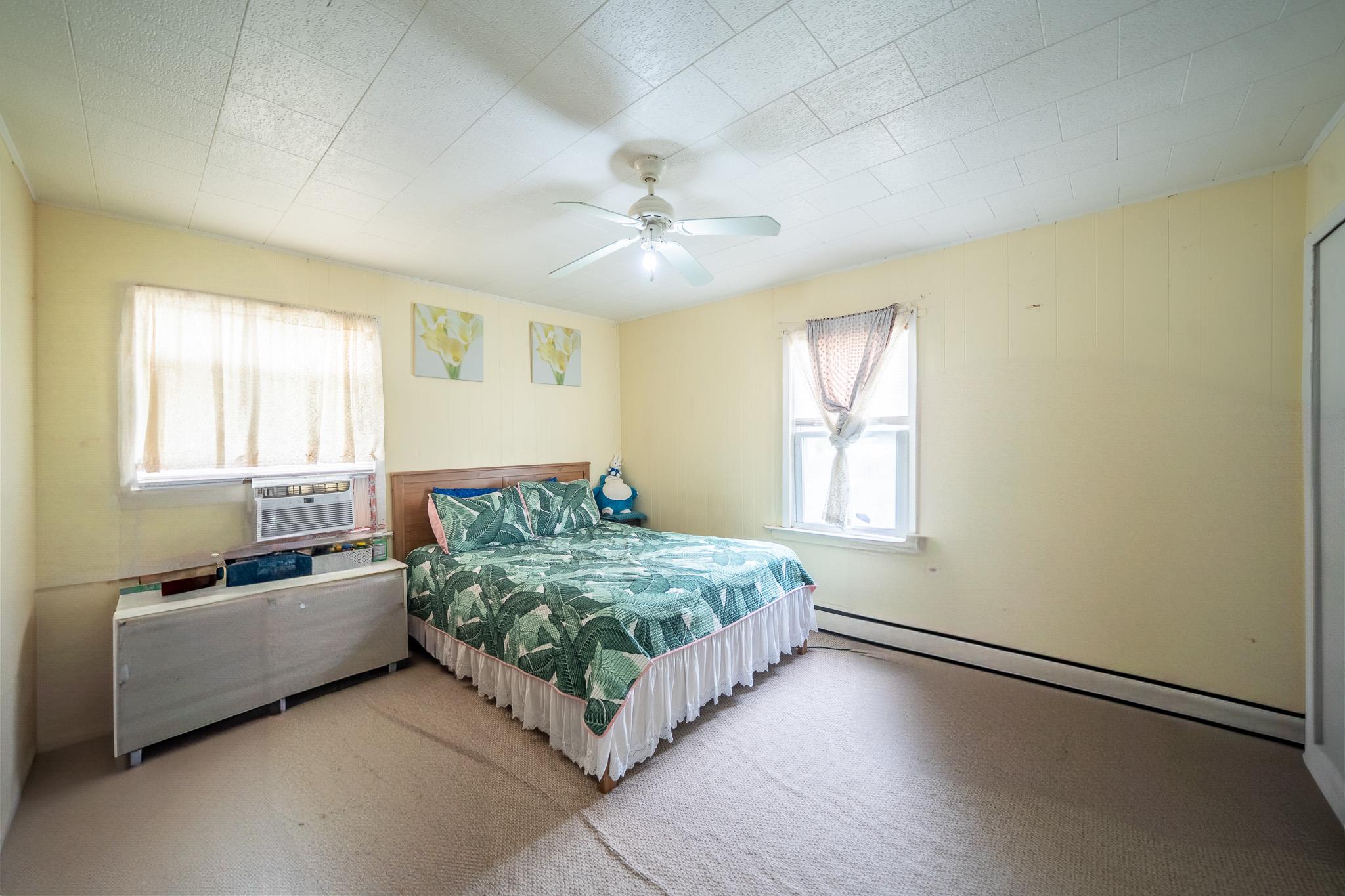 47 Cardinal Road Levittown, NY 11756 - Photo 10 of 27 Carpeted bedroom with baseboard heating, cooling unit, and ceiling fan