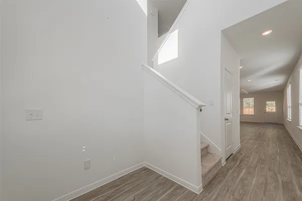 a view of a hallway with wooden floor and staircase