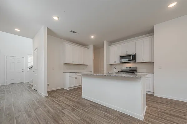 a kitchen with stainless steel appliances a refrigerator and a stove top oven