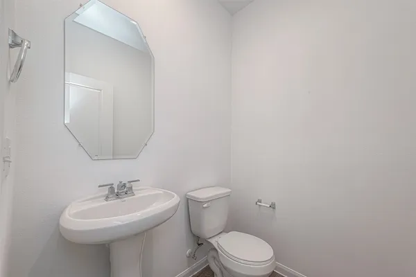 a bathroom with a sink a toilet and mirror