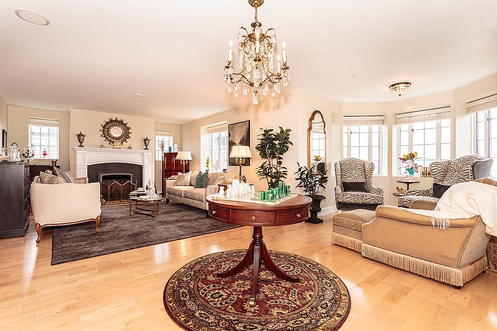 20 Chapel Street, Unit C1001 Brookline, MA 02446 - Photo 1 of 28 a living room with furniture a fireplace and a chandelier
