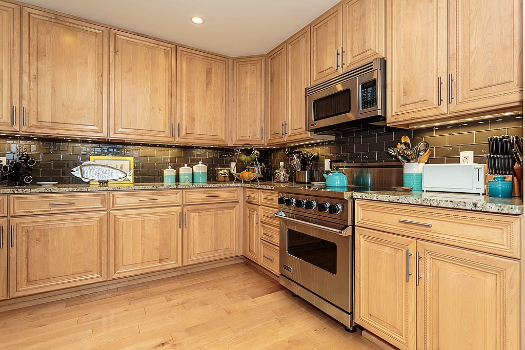 20 Chapel Street, Unit C1001 Brookline, MA 02446 - Photo 14 of 28 a kitchen with granite countertop white cabinets stainless steel appliances and sink