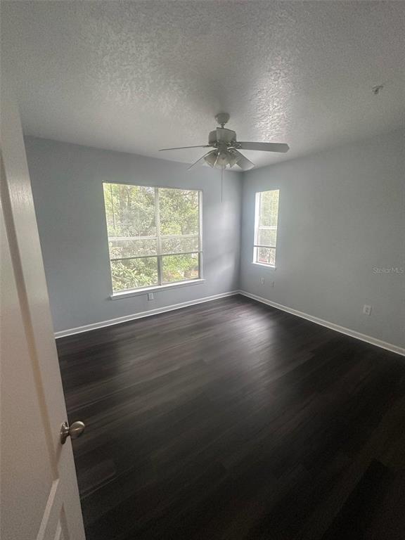 19935 Villa Isle Drive Orlando, FL 32821 - Photo 12 of 17 wooden floor in an empty room with a window
