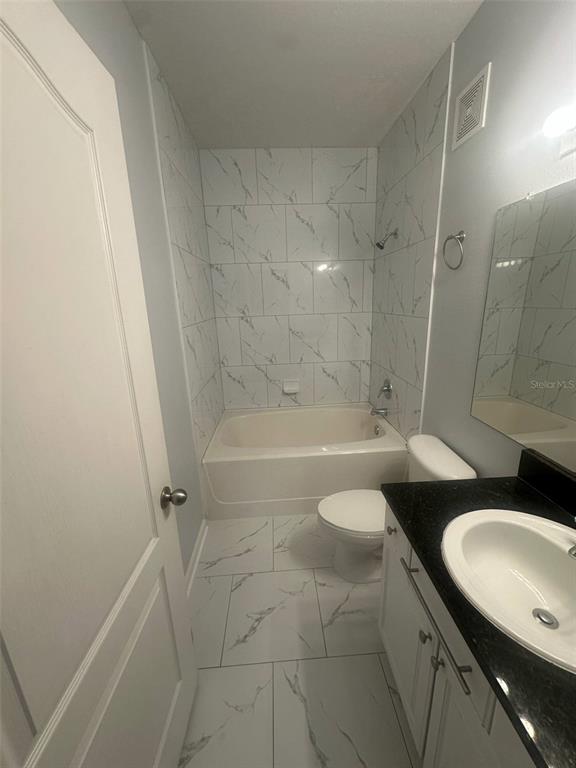 19935 Villa Isle Drive Orlando, FL 32821 - Photo 15 of 17 a bathroom with a granite countertop sink toilet a mirror and shower