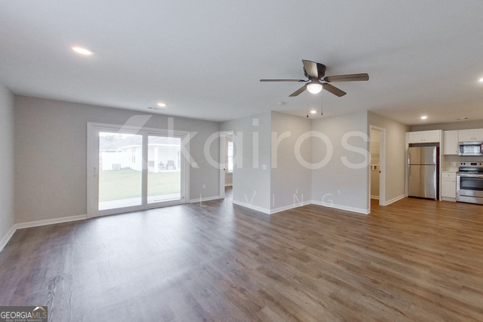 122 Cottage Grove Road Brunswick, GA 31525 - Photo 4 of 20 a view of an empty room with a window and wooden floor