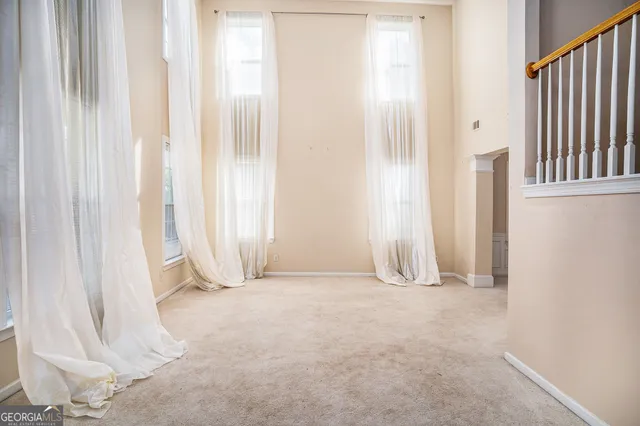 a view of empty room with cabinet and window