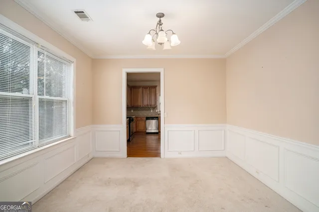 an empty room with wooden floor fireplace and windows