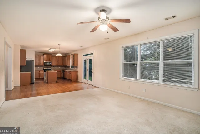 a kitchen with stainless steel appliances granite countertop wooden cabinets a stove a sink and a refrigerator