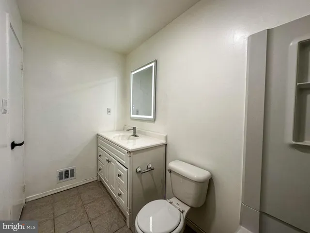 a spacious bathroom with a toilet sink and mirror