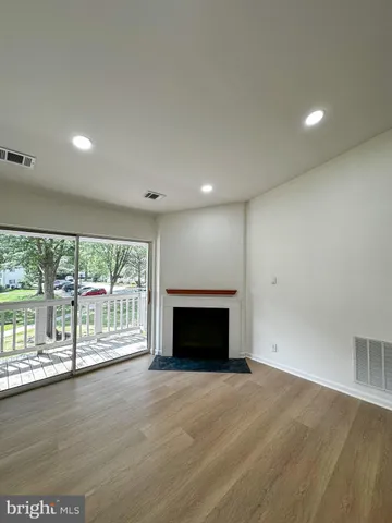 an empty room with floor to ceiling window and wooden floor