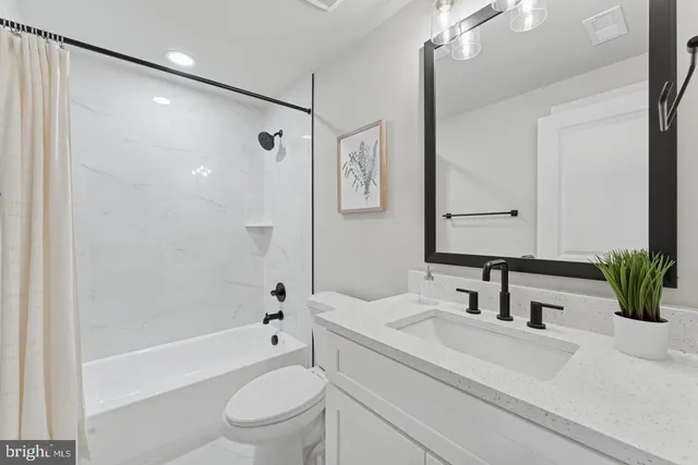 a bathroom with a sink a toilet a tub and shower