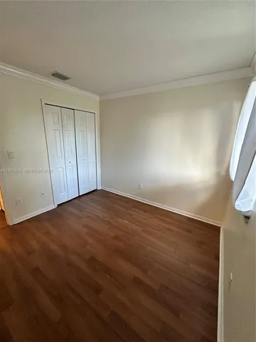 an empty room with wooden floor and windows in it