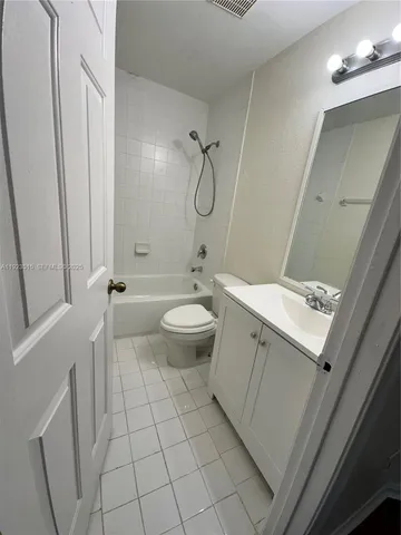 a bathroom with a granite countertop sink a toilet and a mirror