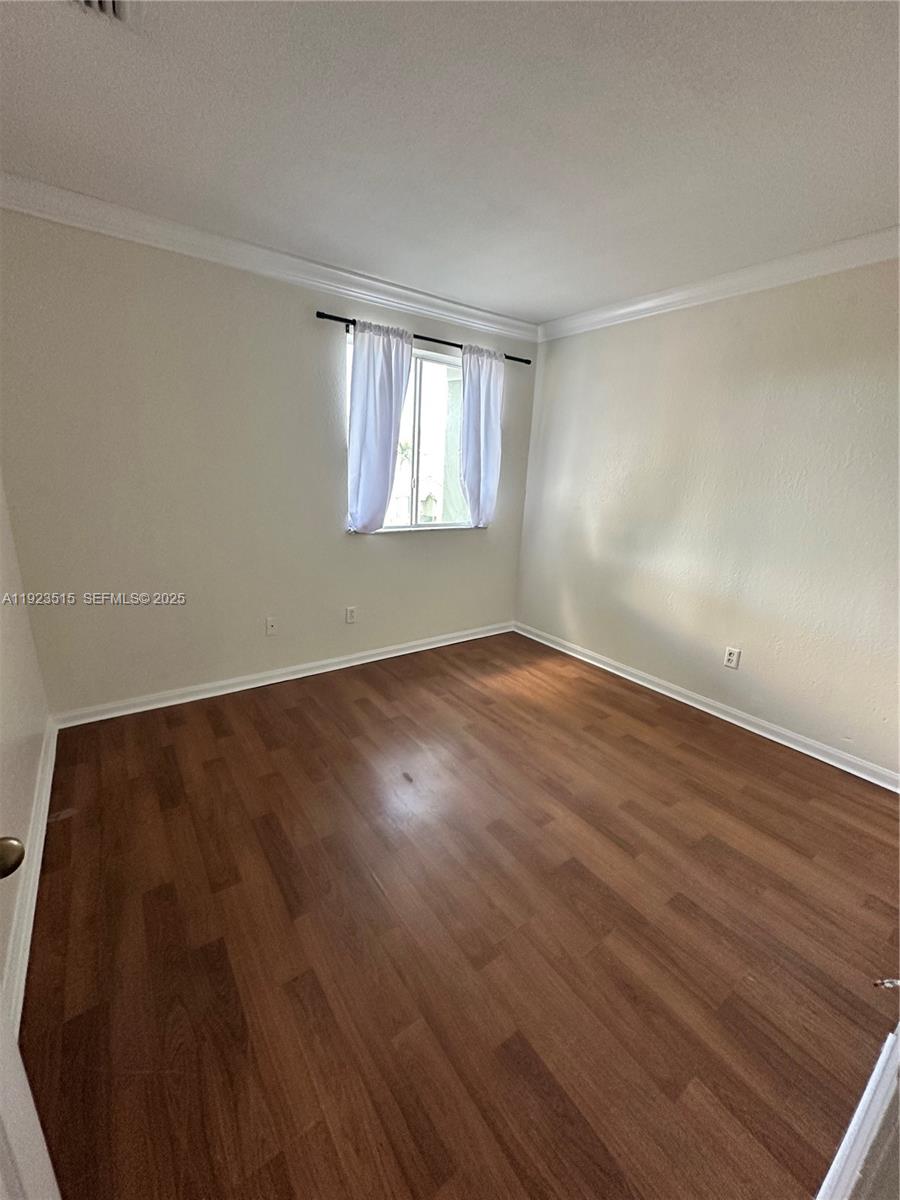 2704 Southeast 15th Place, Unit 152 Homestead, FL 33035 - Photo 21 of 35 a view of an empty room with wooden floor and a window