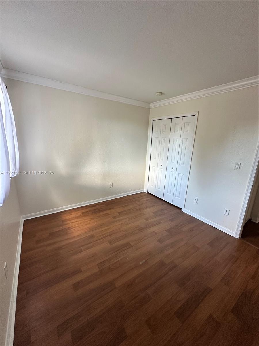 2704 Southeast 15th Place, Unit 152 Homestead, FL 33035 - Photo 22 of 35 a view of an empty room with wooden floor and a window
