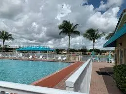 a view of a swimming pool with a garden and trees