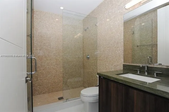 a bathroom with a granite countertop sink toilet and shower