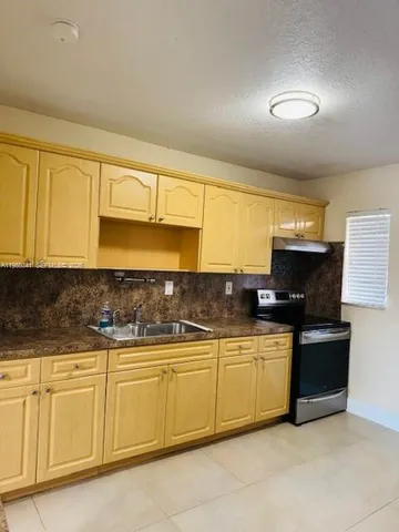 a kitchen with stainless steel appliances granite countertop a sink and a stove