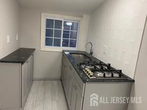 a kitchen with granite countertop a stove and a sink