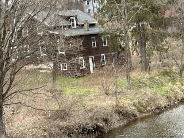 a view of a large house with a yard and a wooden deck
