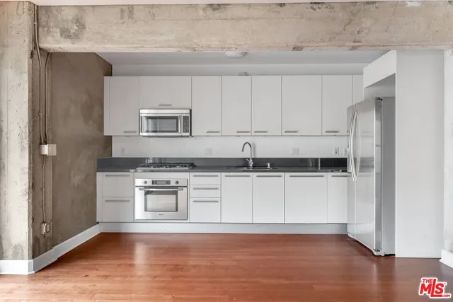 a kitchen with granite countertop white cabinets and white appliances