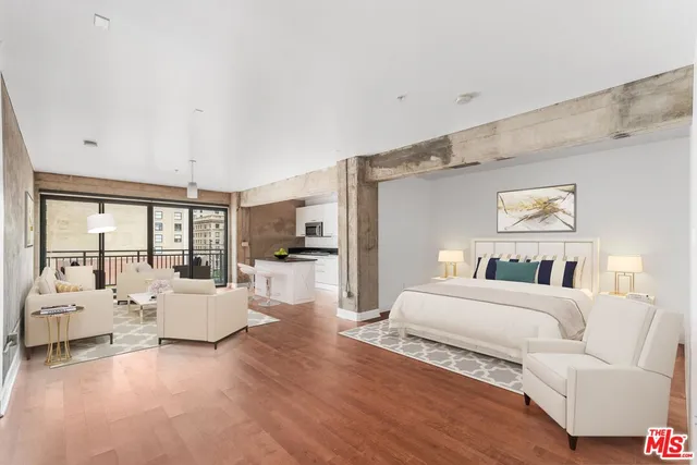 a living room with furniture large window and wooden floor