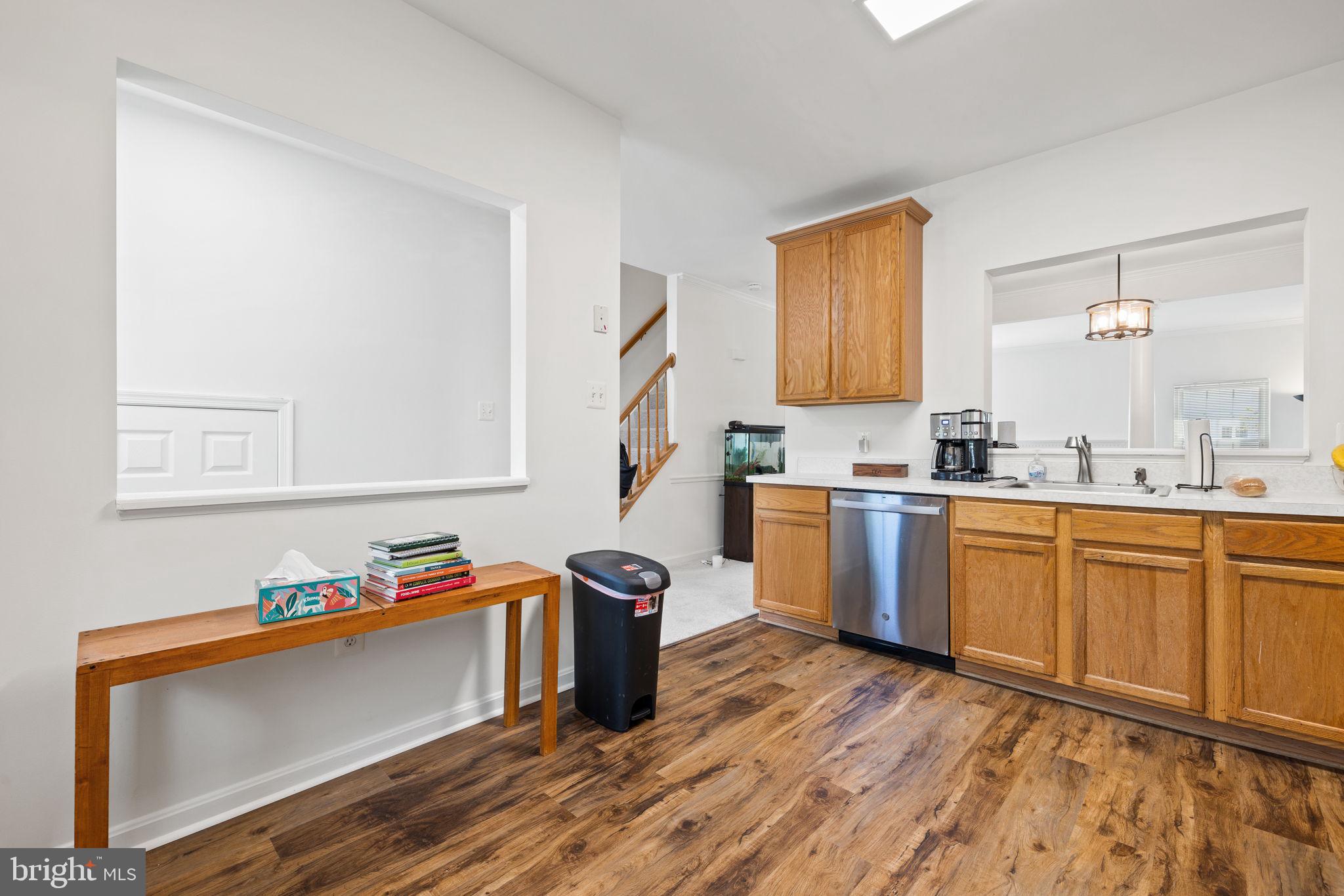 8777 Dunstable Loop Bristow, VA 20136 - Photo 4 of 25 a kitchen with granite countertop a sink cabinets and wooden floor