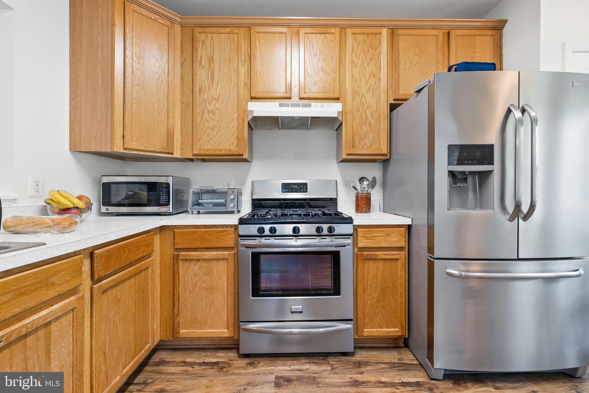 8777 Dunstable Loop Bristow, VA 20136 - Photo 5 of 25 a kitchen with stainless steel appliances granite countertop a refrigerator stove and sink