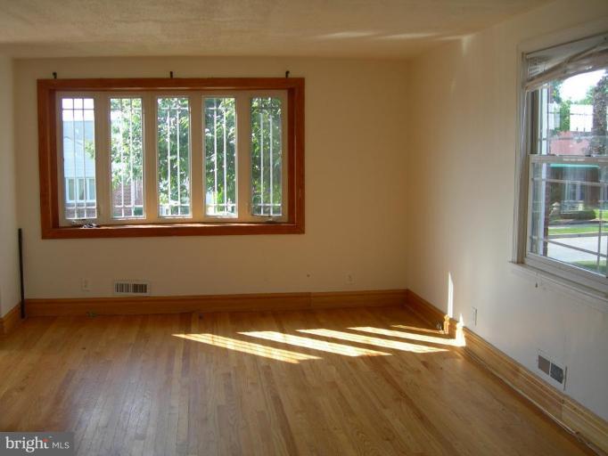 1815 Hanford Road Rosedale, MD 21237 - Photo 2 of 12 an empty room with wooden floor and windows