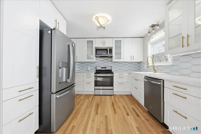 a bathroom with a granite countertop sink a toilet a mirror and shower