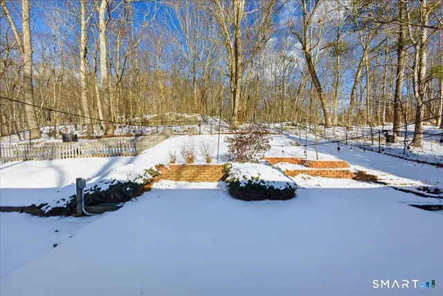 a view of roof deck with a barbeque and wooden fence