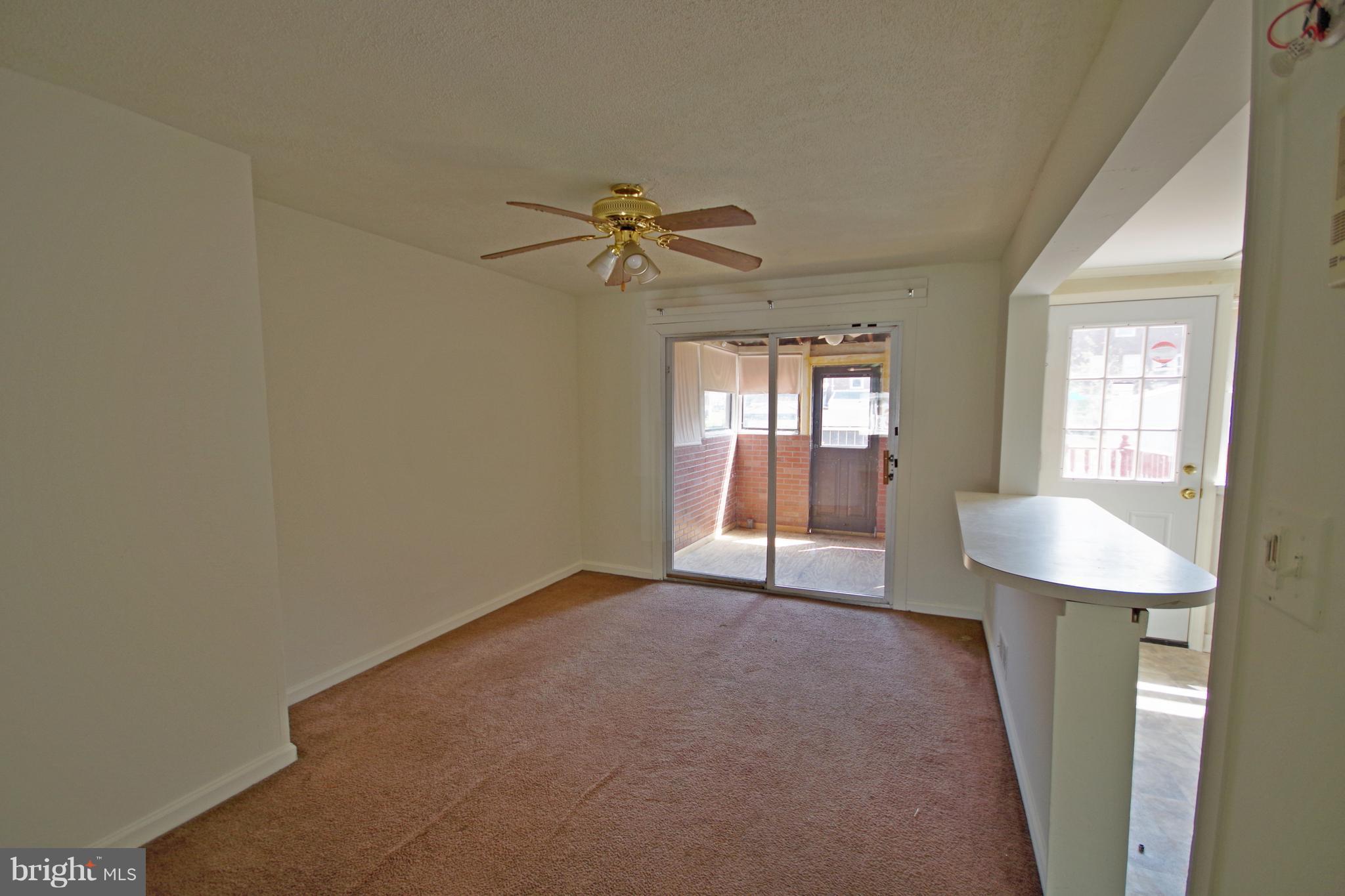7457 Lawrence Road Dundalk, MD 21222 - Photo 7 of 24 an empty room with windows and fan